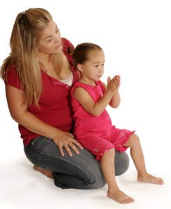 girl signing book with mom