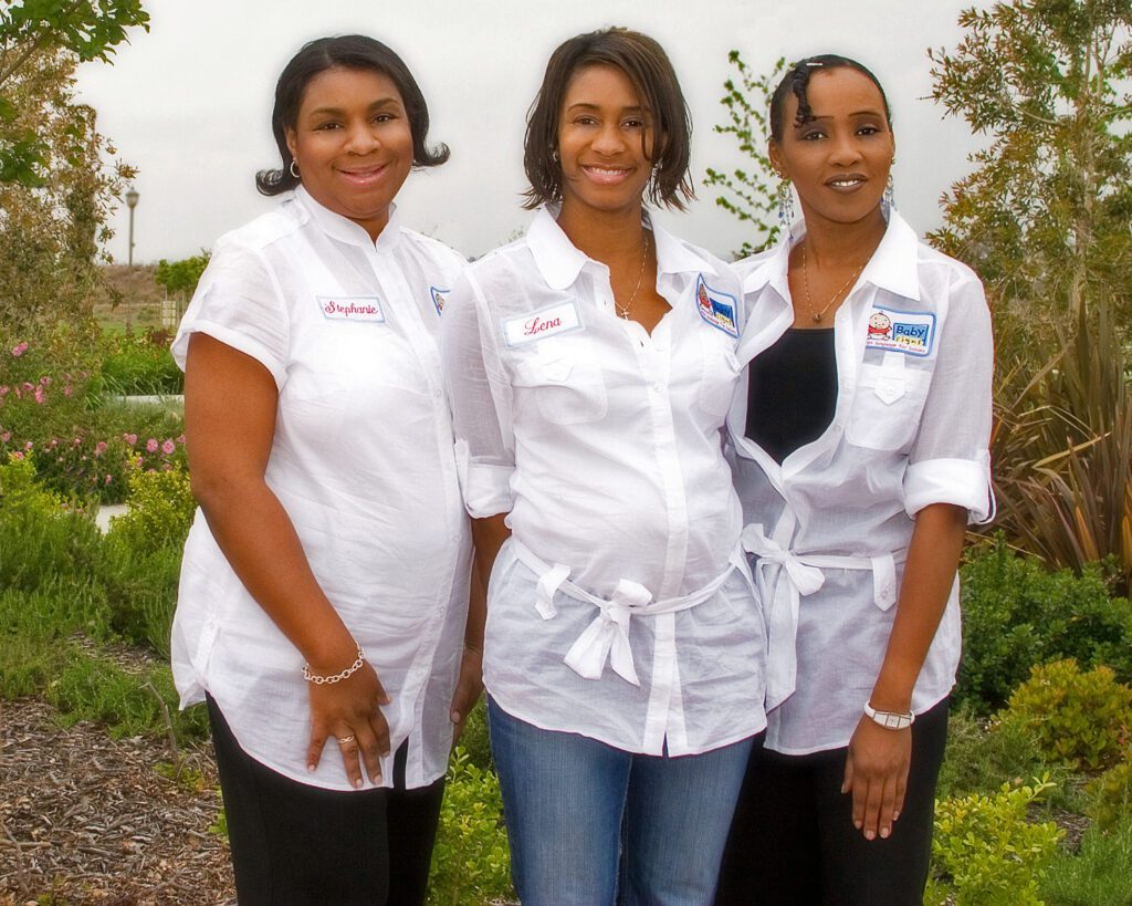 Three women in white shirts Teach Baby Sign Language in a picture.