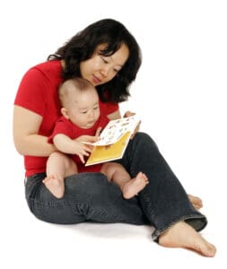 Mother reading a board book with her baby during early literacy routine
