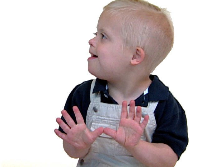 BUTTERFLYwhiteboy A young child with blonde hair, demonstrating early language development, wearing a dark shirt and overalls, smiling and looking to the side with hands up.