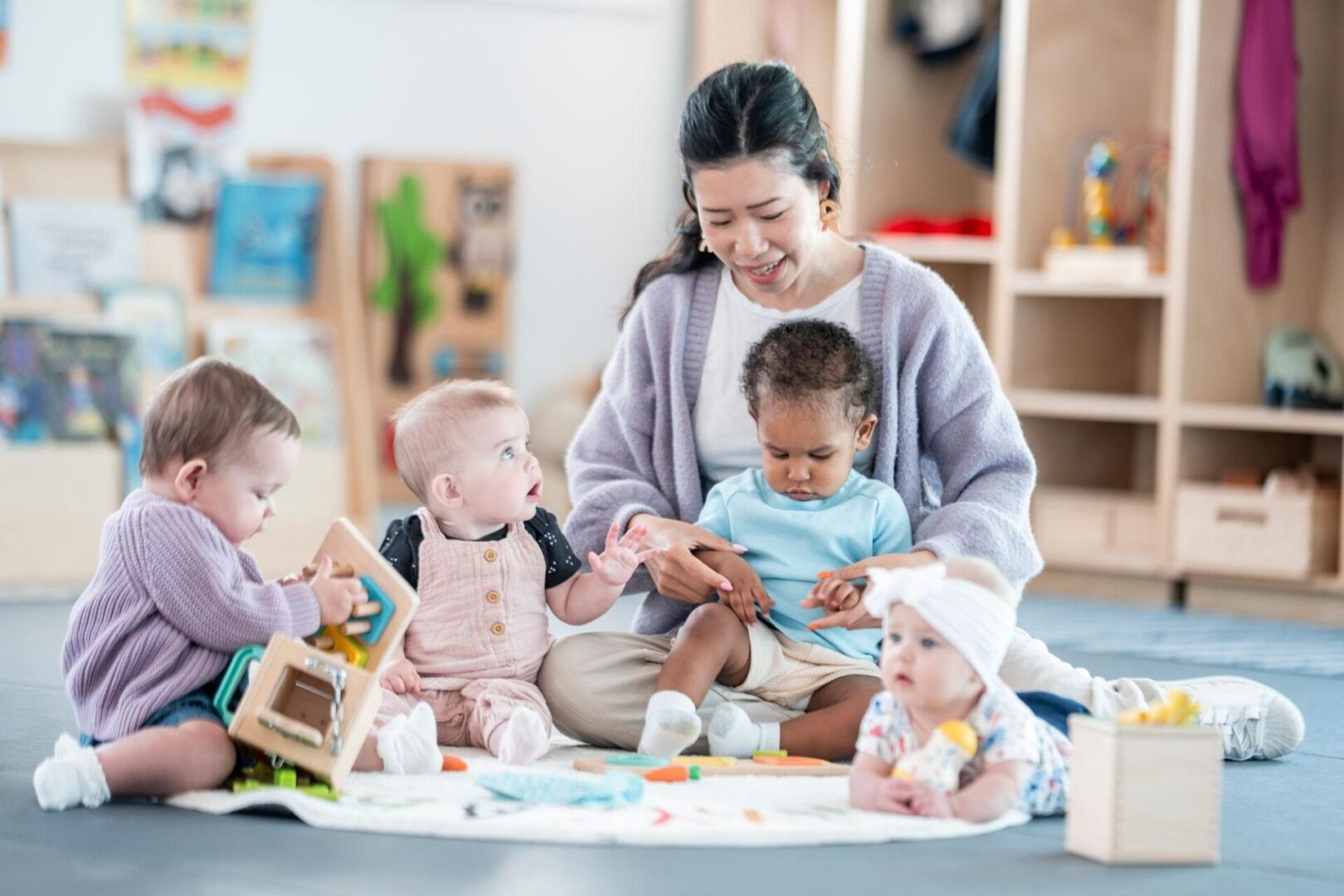 teacher using baby sign language with infants in a classroom to support early communication and learning