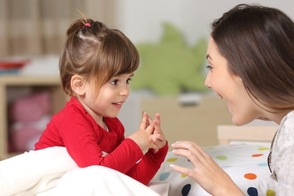 teacher interacting with toddler using baby sign language to support communication and connection