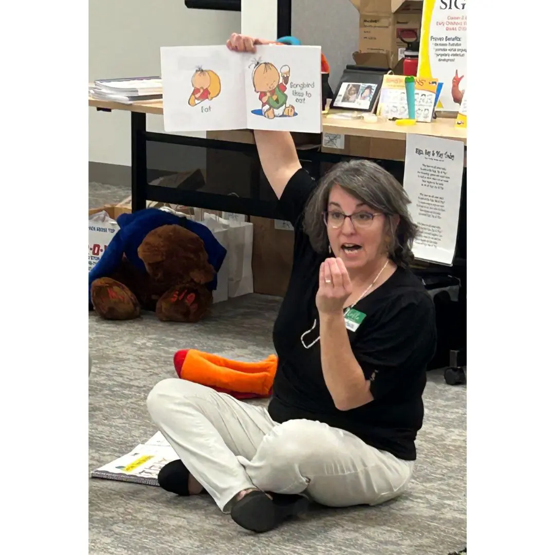 Woman reading a book about a baby.