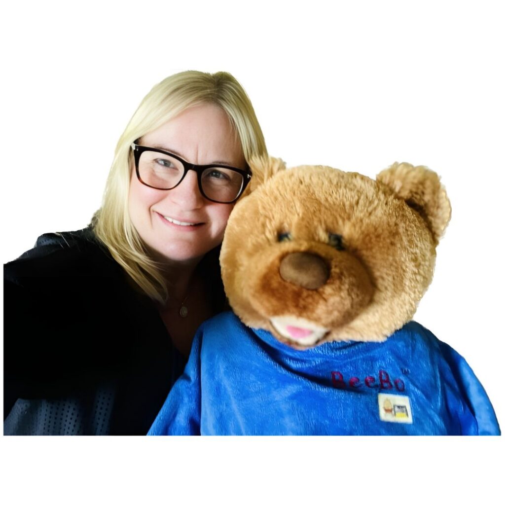 Woman smiling with a brown teddy bear.