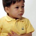 Cute toddler in yellow polo shirt.