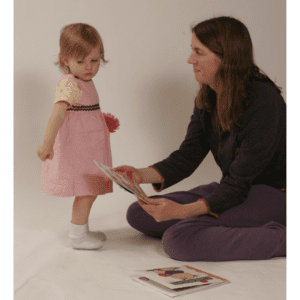 Woman reading book to toddler girl.