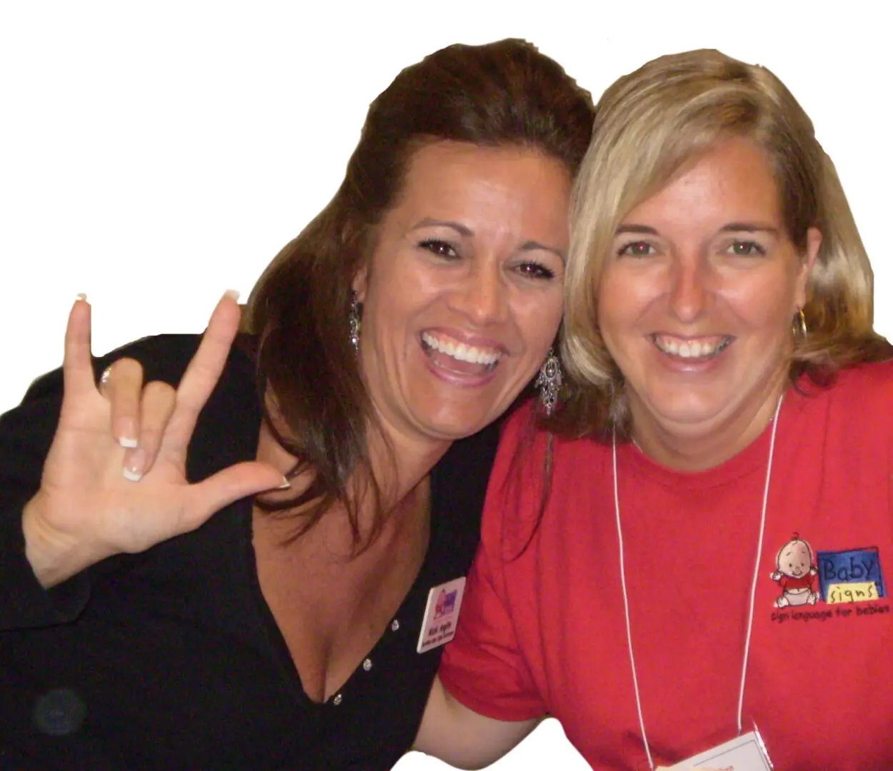 Two women smiling, one signing "I love you."