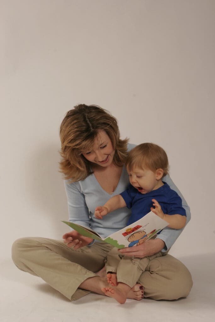 Mother reading with baby while teaching early communication and baby sign language