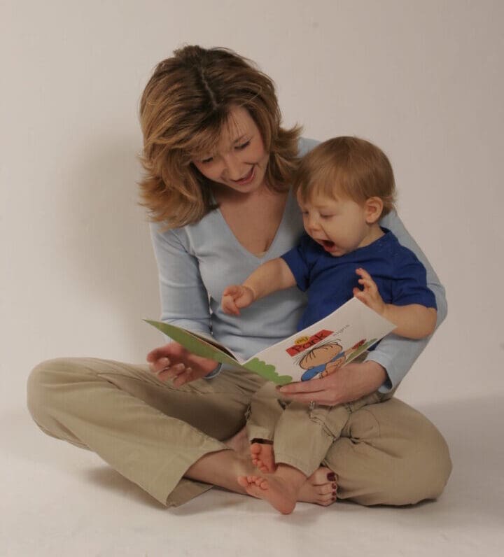 Mother reading with baby while teaching early communication and baby sign language
