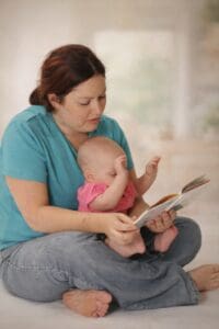 Mother reading with infant while supporting early communication and language development