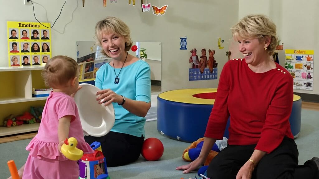 Dr. Linda Acredolo and Dr. Susan Goodwyn interacting with a toddler in an early communication research setting