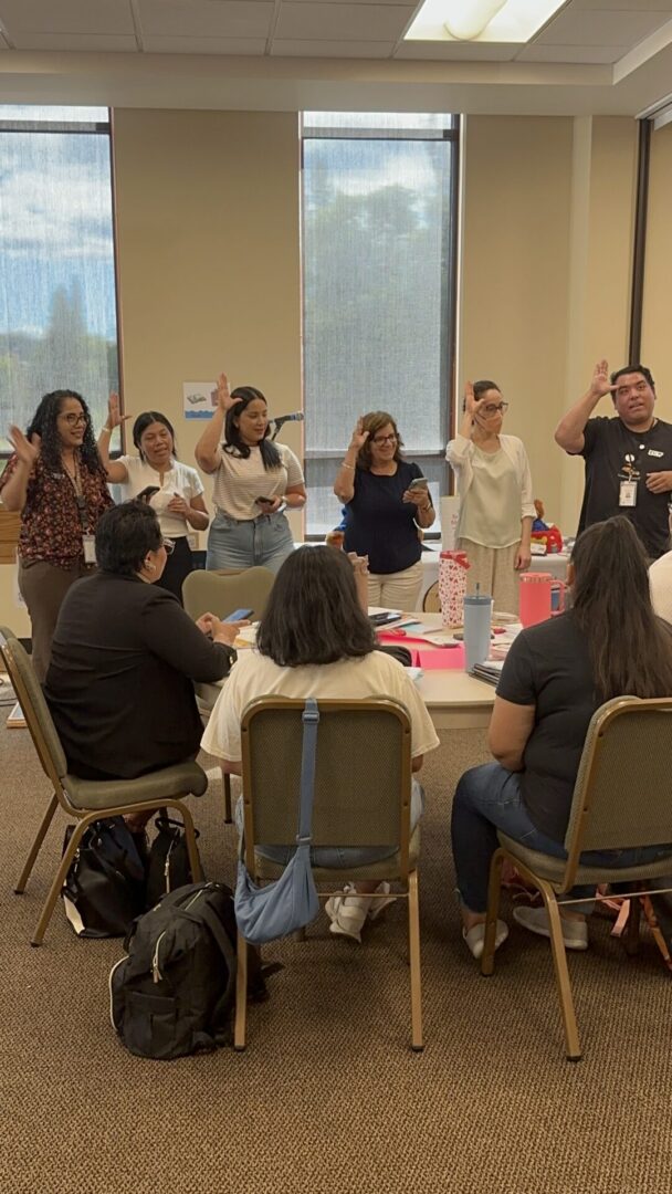 Training participants standing together and practicing signs during an interactive Baby Signs® Instructor Training activity.