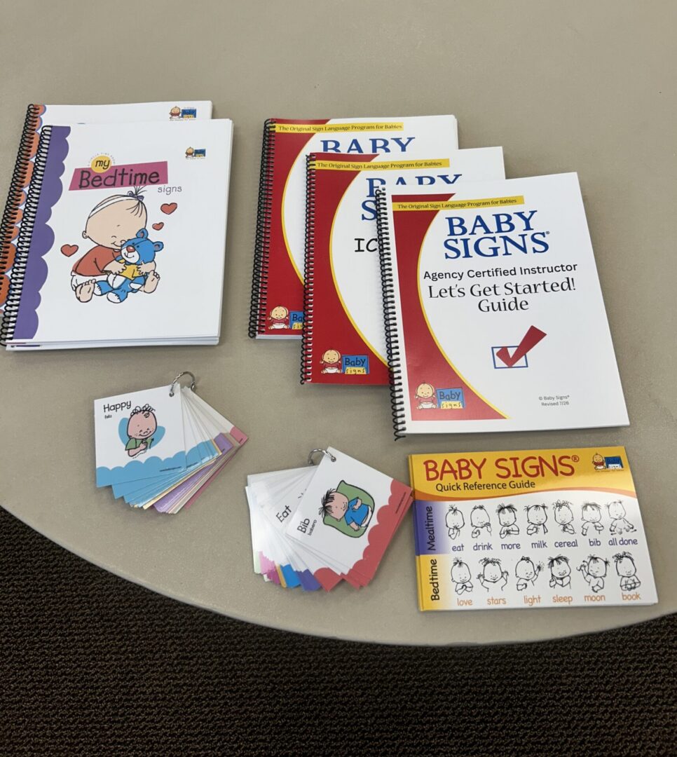 Baby Signs® Instructor Training materials arranged together, including manuals, books, cards, and reference resources.