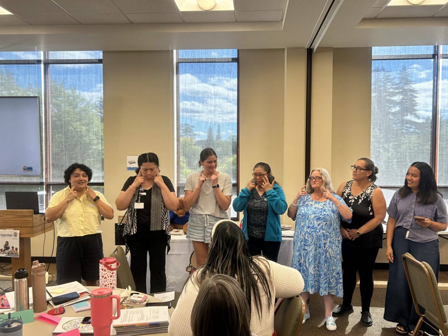 A group of Baby Signs® Instructor Training participants standing and practicing signs together.